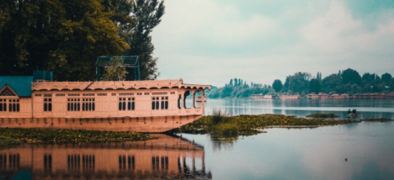 A houseboat moored on a still mountain lake